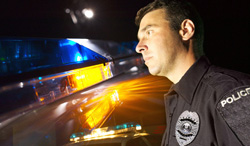 police officer with lights in background