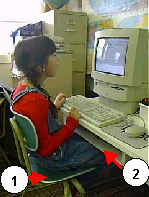 picture of a child at a computer desk where the monitor is too high but the child's legs are touching the keyboard tray.