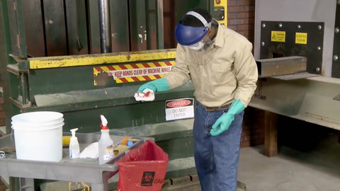 screen shot from video with person in protective gear throwing away bloody rag