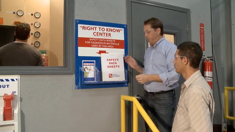 Imagen fija del video con un hombre señalando un libro de Hojas de Datos de Seguridad a otro hombre.